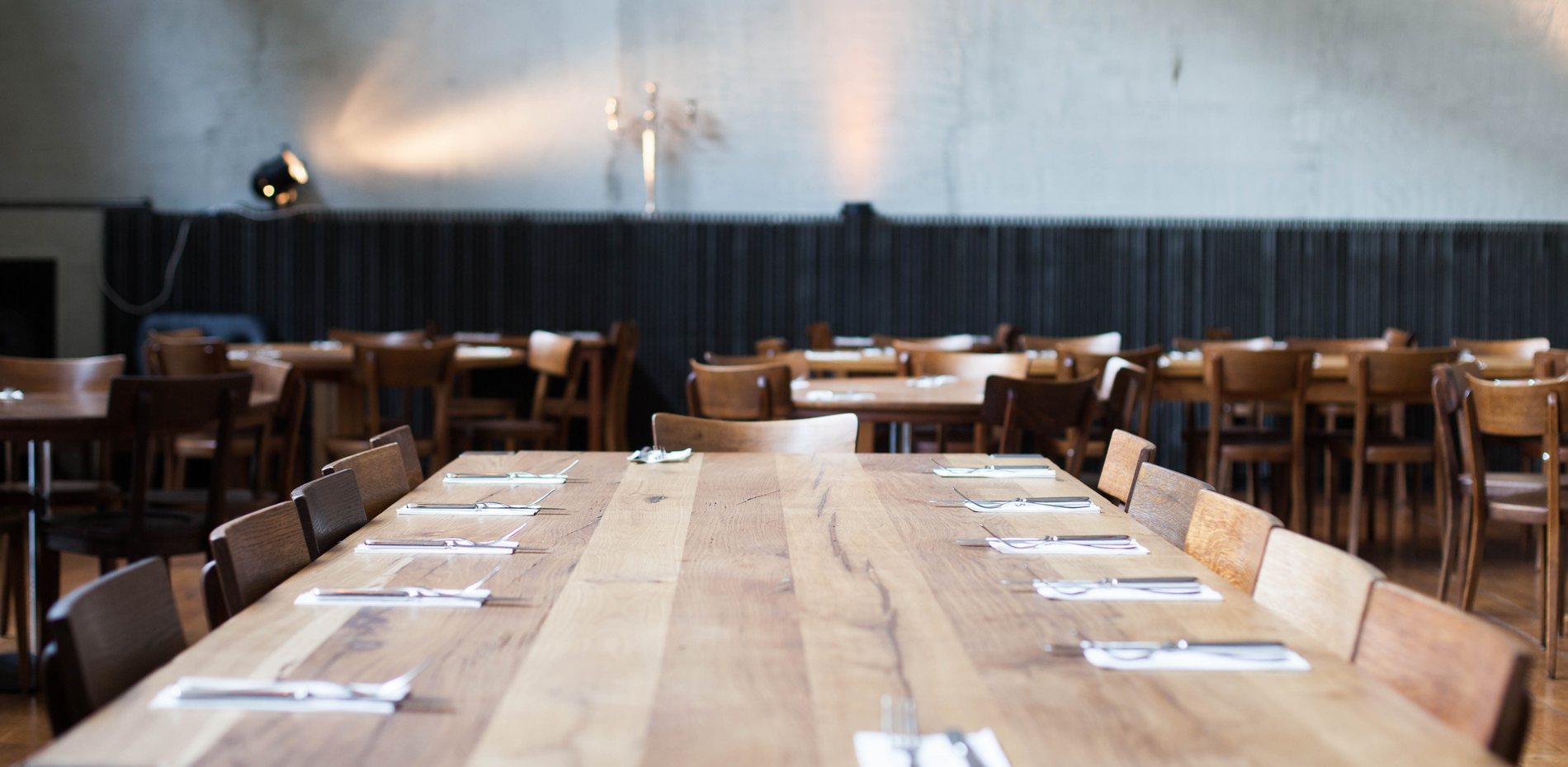 Restaurant im schmatz mit langen Holztafeln und Bar