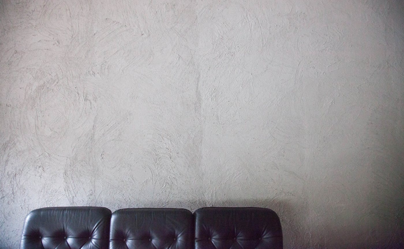 Detail: Ledersessel vor Betonwand